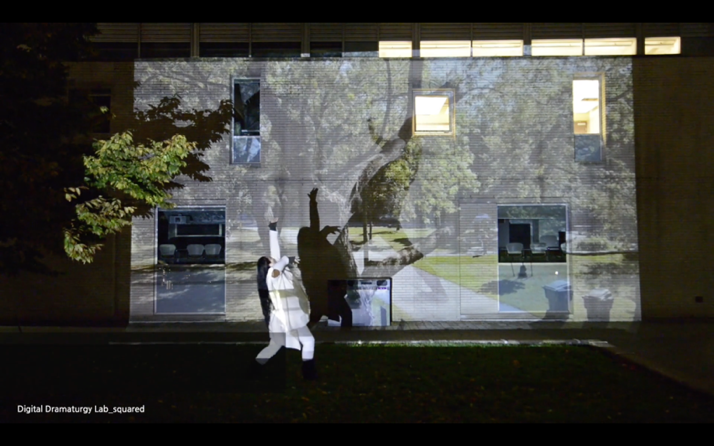 Performance artist in front of projected background of trees