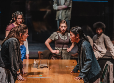 Actors Phaedra Archimandriti (Noah) and Hannah Chown (Chris) face each other from across a table